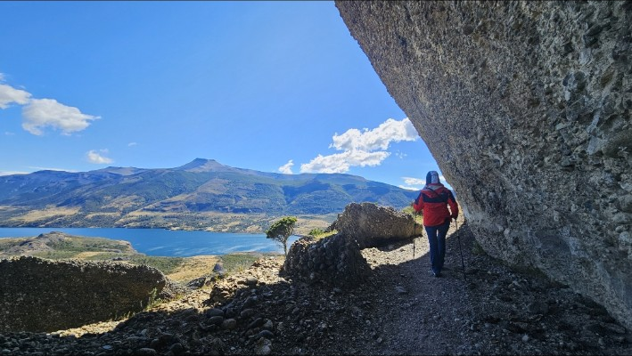 Sendero bajo pared rocosa en Rupestre Patagonia